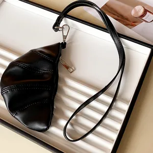 Primer plano de un collar monedero de cuero sintético negro con forma de croissant.