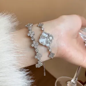Elegant silver-toned bracelet set with sparkling zircon flowers and clover charms