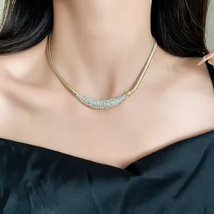 Detailed view of gold crescent pendant necklace with pavé crystal rhinestones