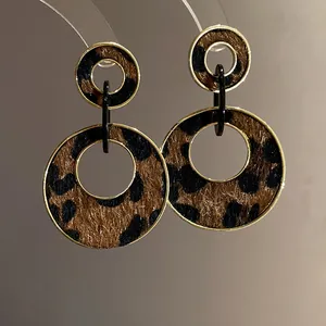 Macro view of retro leopard print double hoop drop earrings with elegant golden frame