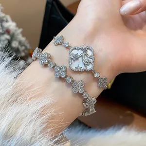 Macro detail of silver-colored bracelets featuring sparkling zircon flower and clover designs