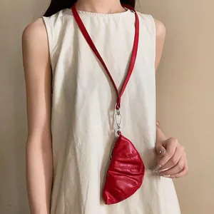 Vista detallada de un collar monedero de media luna en cuero sintético rojo en una modelo