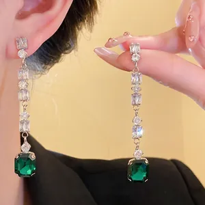 Elegant long drop earrings with green emerald-cut stones and sparkling zircons.
