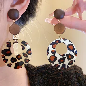 Close-up detail of vintage leopard print wooden earrings in Maillard brown tones