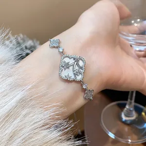 Macro view of a delicate silver flower bracelet with sparkling zircon and floral inlay detail