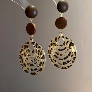 Detailed view of retro leopard print oval earrings with wooden beads in Maillard style