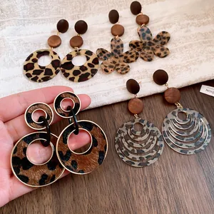 Detailed view of leopard print and wooden vintage style earrings in Maillard tones