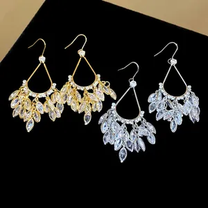 Close-up of 18k gold and silver teardrop fringe earrings with sparkling marquise zircons
