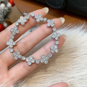 Close-up of a sparkling zircon flower bracelet held over a soft white fur background