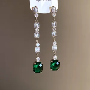 Elegant long tassel dangling earrings with emerald green square gemstone and sparkling zircons.
