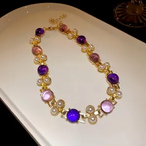 French vintage geometric pearl necklace with purple and pink beads on a white porcelain tray