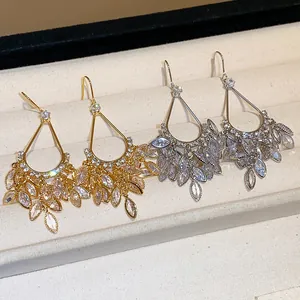Detailed shot of 18k gold-plated zircon water drop tassel earrings in gold and silver