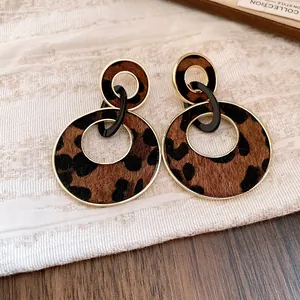 Detailed close-up of vintage leopard print double hoop drop earrings with gold finish.