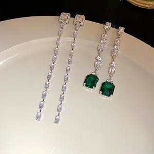 Detailed macro view of sparkling emerald green stone and cubic zirconia tassel earrings