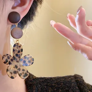 Close-up of vintage leopard print flower earrings with wooden beads in Maillard style
