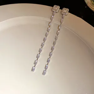 Detail view of silver tassel earrings with sparkling rectangular cubic zirconia stones.