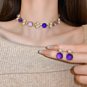 Close-up of French vintage gold-tone necklace with purple stones and pearls on a model