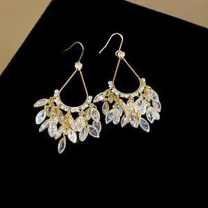 Macro detail of 18k gold plated earrings with sparkling marquise cut zirconia