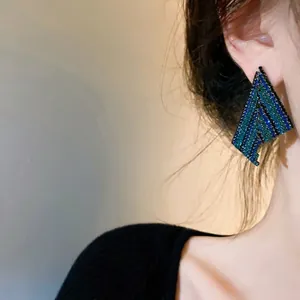 Elegant fan-shaped geometric stud earrings with sparkling blue and green crystal stripes