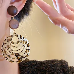 Close-up of retro leopard print multi-layer circular drop earrings with wooden studs.