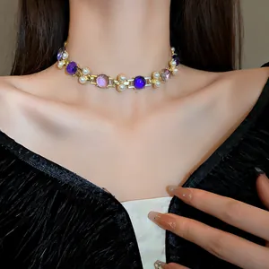 Detail view of a French vintage gold choker necklace featuring pearls and purple stones on a model