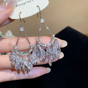 Close-up of 18k gold plated zircon teardrop tassel earrings with intricate palace style detail.