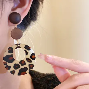 Detailed view of vintage leopard print wooden drop earrings with a matte finish