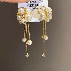 Elegant gold tassel earrings with clustered pearls and sparkling cubic zirconia floral design.