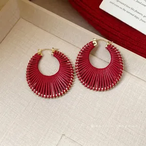 Elegant red woven hoop earrings with gold-toned hardware for a stylish fashion look