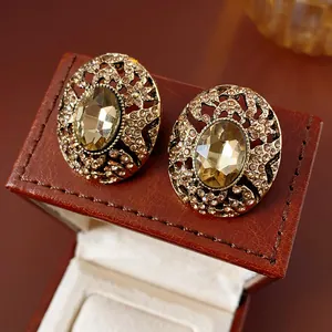 Gros plan de boucles d'oreilles vintage avec zircon champagne et finition or antique.
