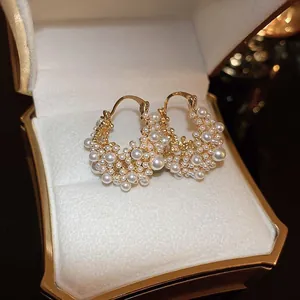 Elegant vintage style gold-plated hoop earrings featuring clusters of white pearls.