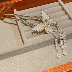 Macro view of gold butterfly hair stick with rhinestones and elegant pearl tassels