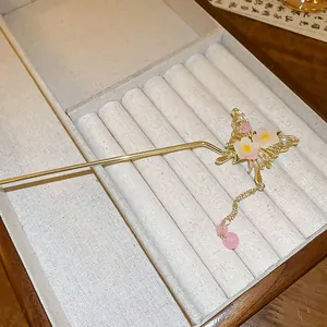 Detail of elegant butterfly hair stick with floral accents and pink bead tassel