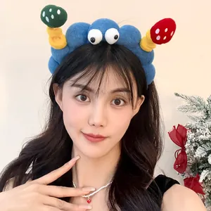 Close-up of a quirky blue cartoon headband with eyes and mushrooms on an Asian woman.