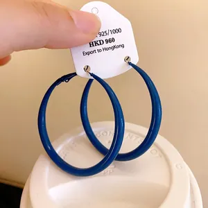 Large Klein blue hoop earrings featuring a simple circular spray-painted minimalist design.