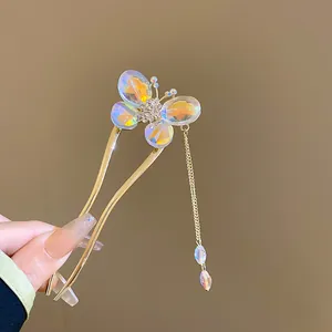 Detailed shot of gold-tone butterfly hair fork with iridescent crystal wings and tassel