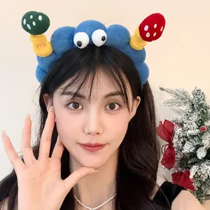 Close-up of a model wearing a cute blue cartoon plush headband featuring funny decorative eyes