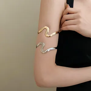 Elegant minimalist wavy metal arm cuff bracelet in polished gold and silver finishes