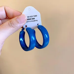 Detail shot of minimalist Klein blue hoop earrings with a glossy spray-painted finish