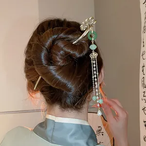 Detail of elegant Neo-Chinese hair stick featuring pearl tassels and green beads in a bun