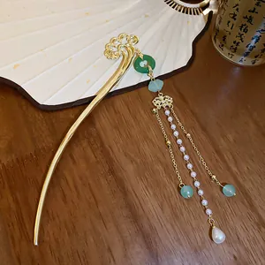Detailed view of an elegant gold hair stick with pearl tassels and jade beads