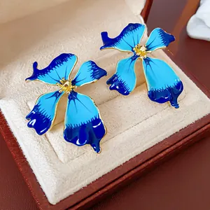 Close-up of vintage blue enamel flower earrings with gold-tone detailing