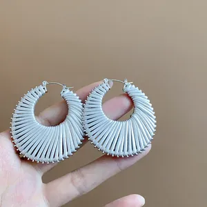 Macro detail view showing the fine silver-tone ribbed texture of round hoop earrings