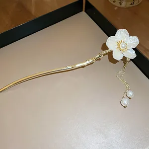 Close-up detail of an elegant Chinese style hair stick featuring a white flower and pearl tassel