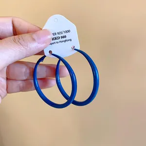Macro detail of Klein blue minimalist painted hoop earrings featuring sterling silver needles