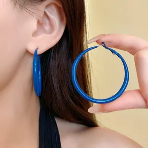 Detailed close-up showing the vibrant Klein blue spray paint finish on large hoop earrings