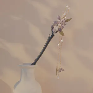 Close-up detail of a traditional Chinese hair stick with purple flowers and pearl tassels.