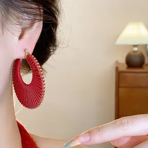 Detailed macro shot of elegant red woven hoop earrings showing exquisite craftsmanship