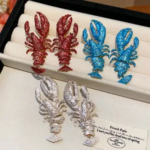 Detailed view of oversized textured lobster earrings in red, blue, and silver metallic finishes