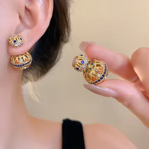 Detailansicht vintage 18k vergoldeter Hohl-Ohrringe mit bunten Zirkonia-Steinen.